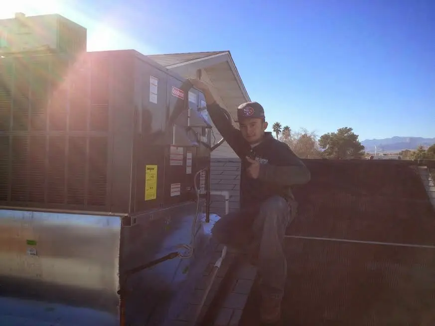 HVAC technician performing AC Tune-Up on a rooftop unit in Covina